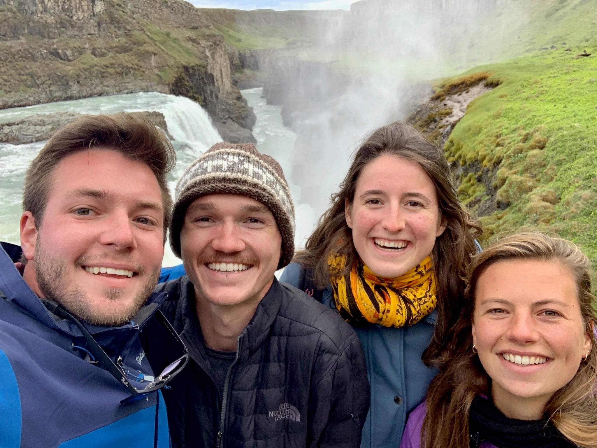 the Footy Intl founders taking a selfie in Iceland in front of a canyon with a blue glacial river flowing behind them