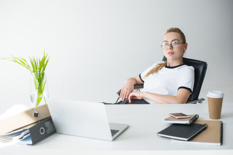 Businesswoman avoiding digital eyestrain by looking away from laptop screen