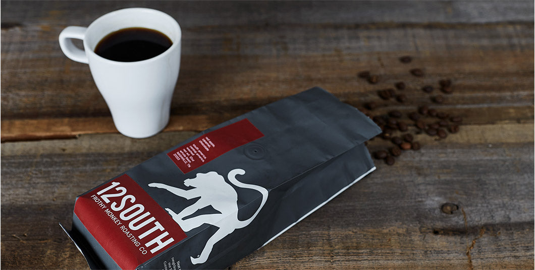 Frothy Monkey cup of coffee and coffee grinds packaging