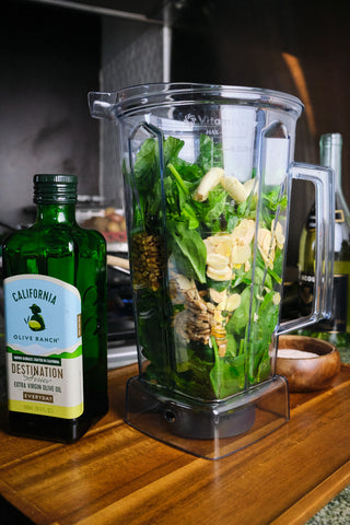 Photo of a blender with pesto ingredients inside