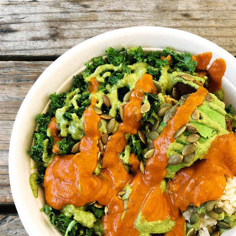 A dale bowl up close, smothered in bright red hot sauce.