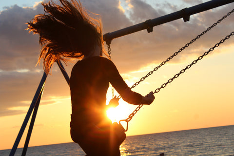 Woman on a swing at sunset