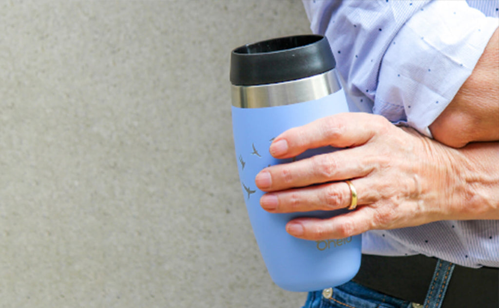 Ohelo blue swallows travel cup with woman holding it