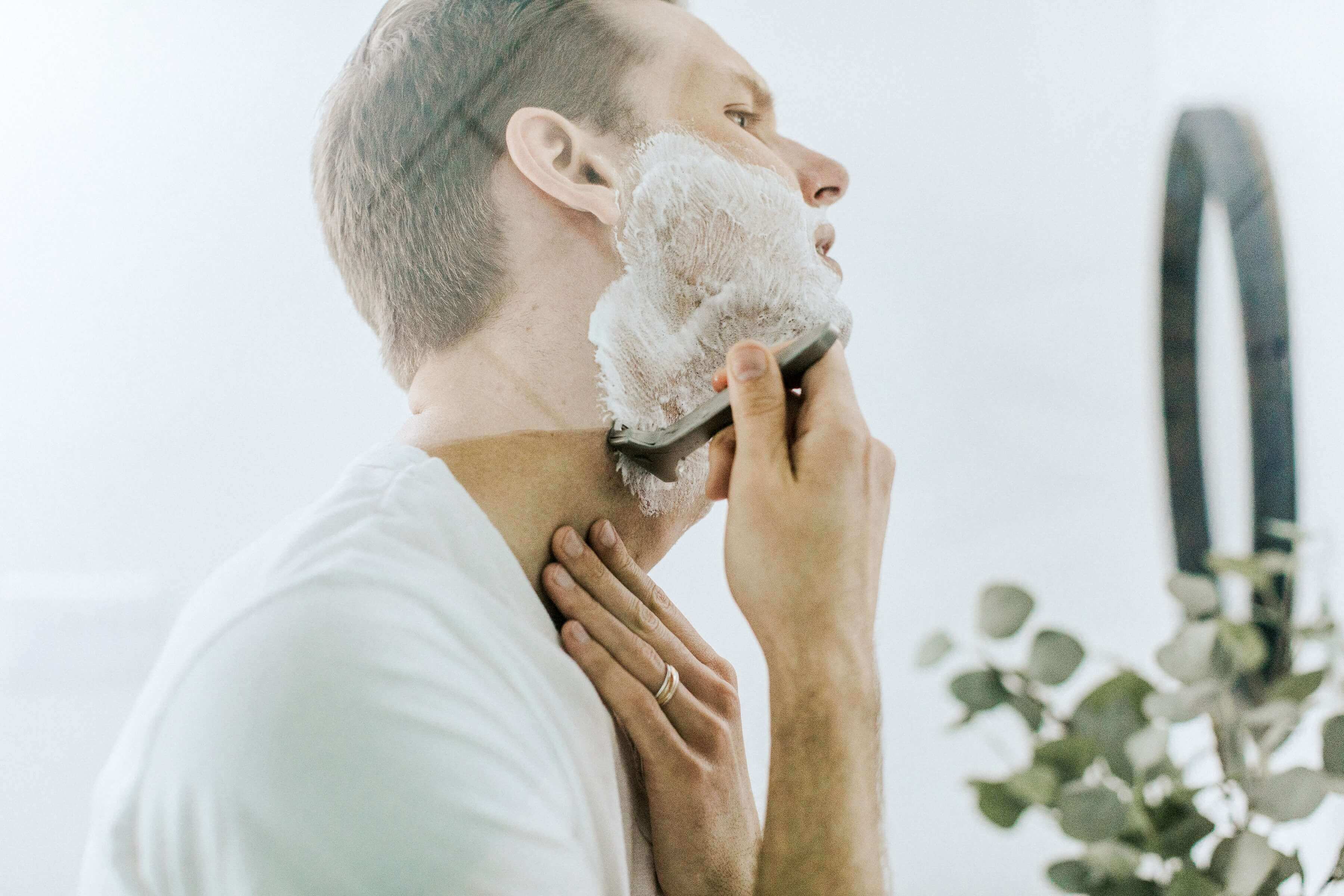 Man shaving in bathroom