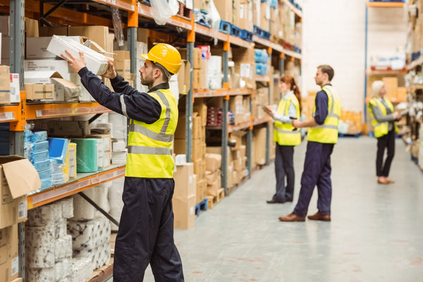 workers in a warehouse wearing saftey gear