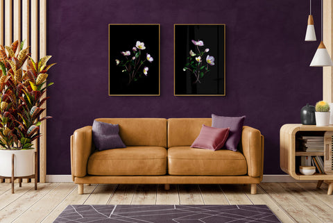 two large vertical Hellebore botanical prints displayed on a dark wall above a sofa