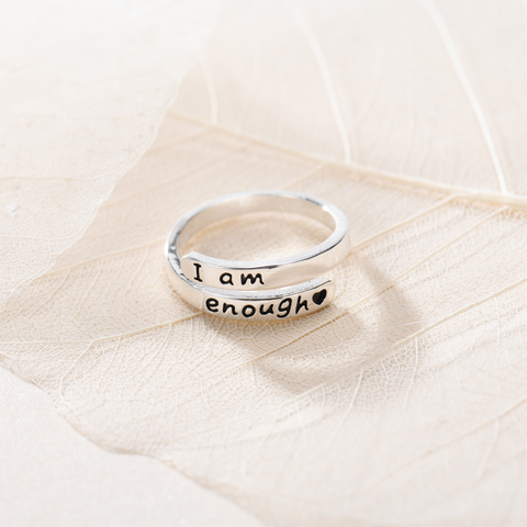 Thin Wrap 'I Am Enough' Ring on top of a leaf