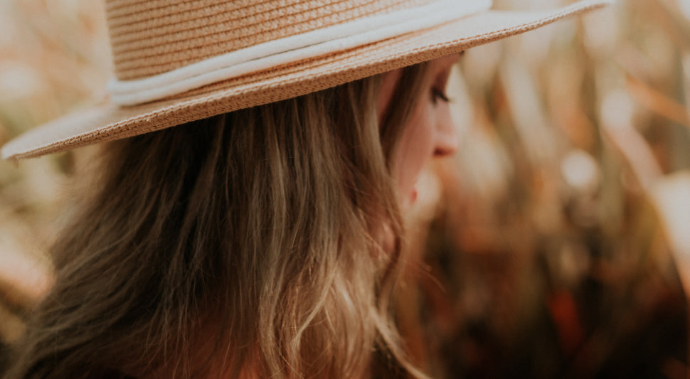 A woman wearing a hat looking down