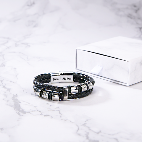 Leather bracelet placed on top of table together with small white gift box