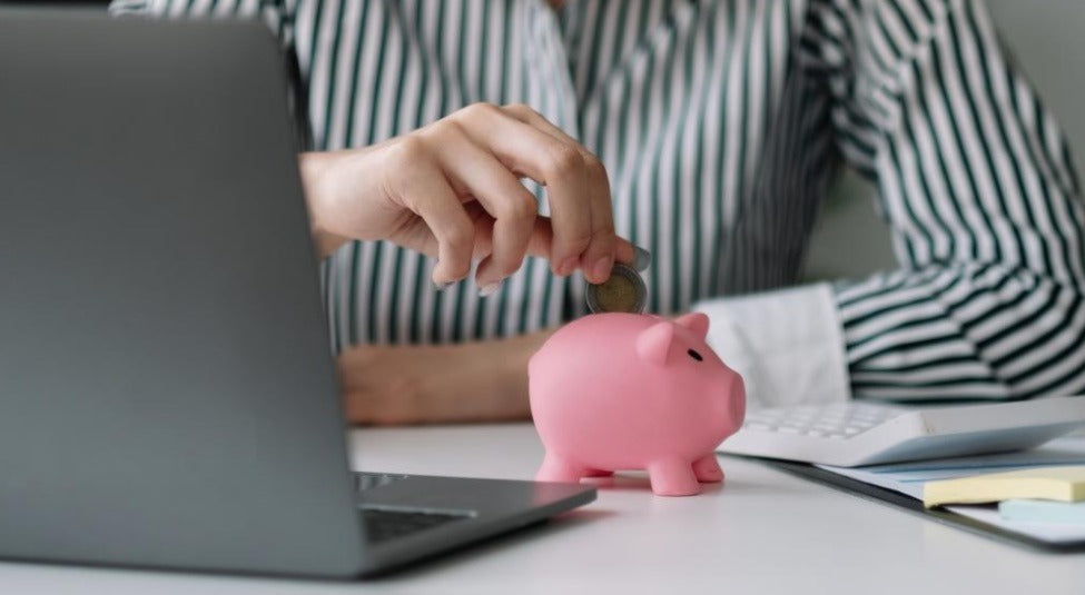 A female model inserting a coin on her piggy bank