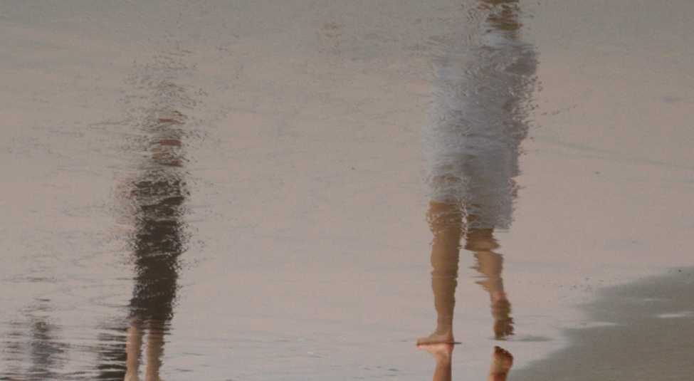 Reflection of two people on the water