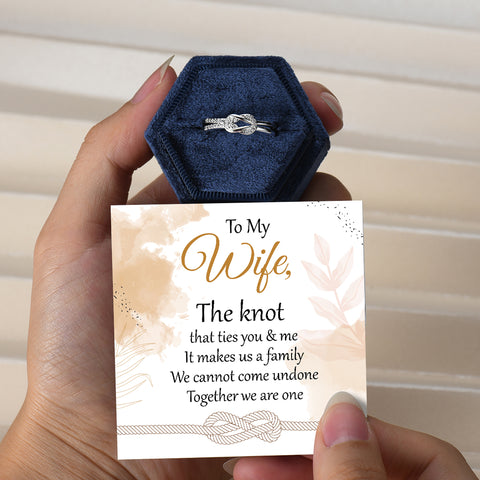 To My Wife Love Knot Ring in a case behind an inspirational note