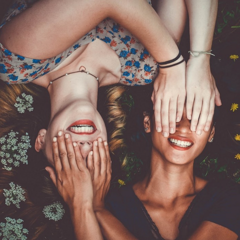 two models lying down and covering eachother's eyes
