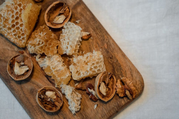 Honeycomb on wooden board with walnuts