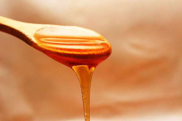 Raw honey dripping from a spoon
