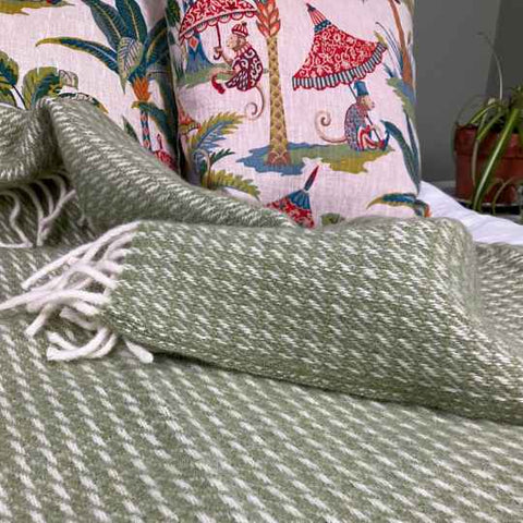 green wool blanket on a bed