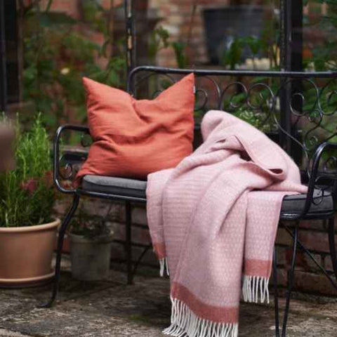 Pink wool throw on a bench.