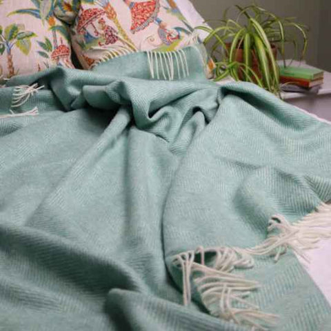 Green wool blanket on a bed
