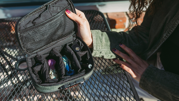 Girl opening Dime Bags Goodfella case showing internal organization. Case contains pipes and lighter.