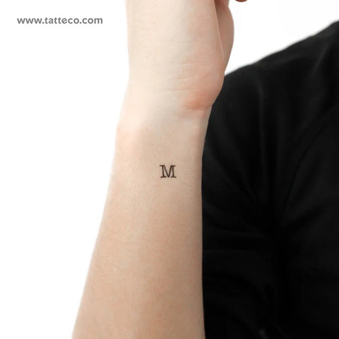 Friendship tattoos: A small captial M temporary tattoo on the wrist