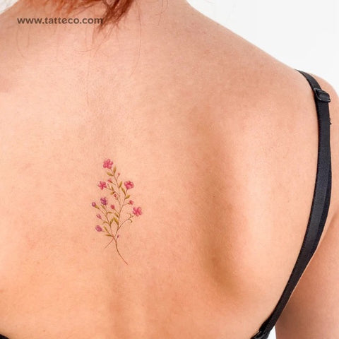 Matching sister tattoos: Pink flower tattoo on the back