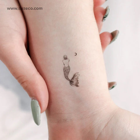 Moon phase tattoo: mermaid tattoo with a crescent moon in the fine line style