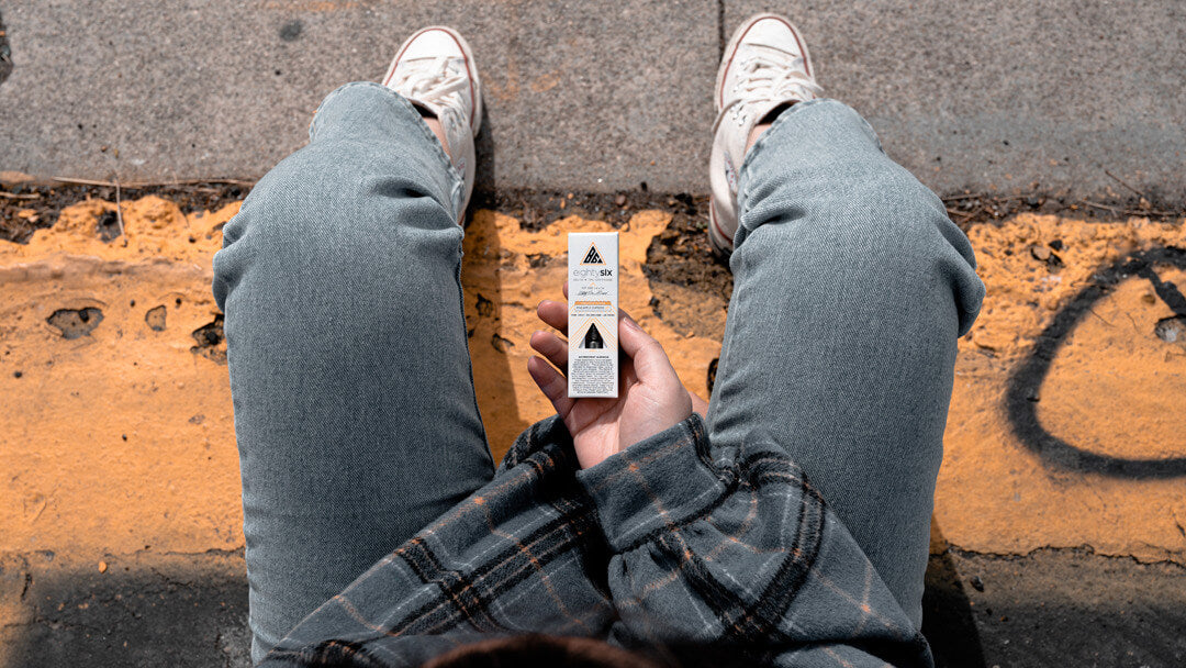 person sitting holding eighty six delta-8 thc vape