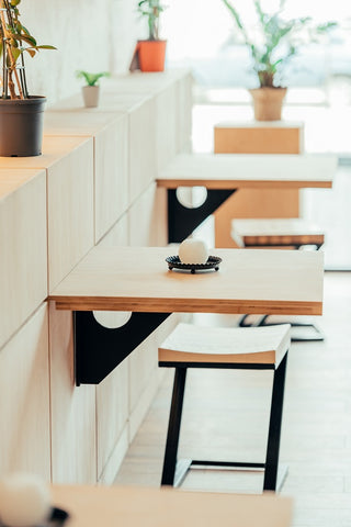 Photo of interior of modern cafe with small tables on wall 