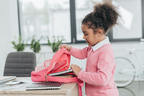 Photo of a nice little girl getting ready for school