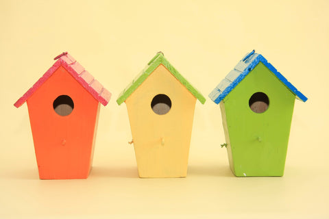 Photo of three birdhouses on a yellow background 