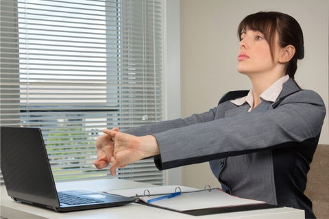 Photo of a woman doing an exercise for the carpal tunnel at the workplace