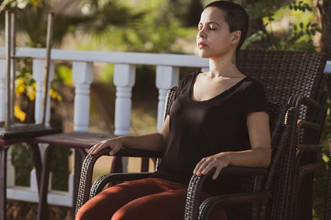 Photo of a woman sitting on a chair and doing meditation 