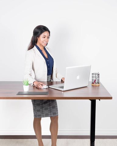 Photo of a businesswoman with a laptop at a standing desk