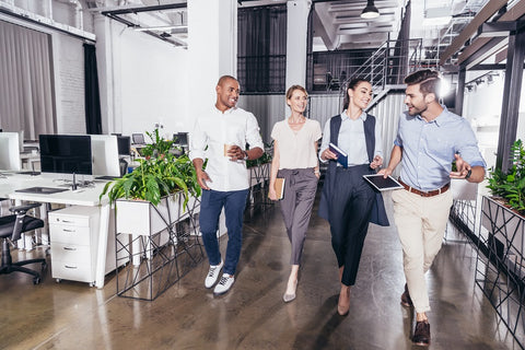 Photo of young smiling multiethnic business colleagues walking together in an office
