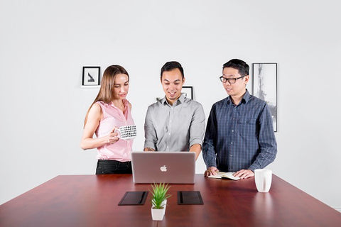 Photo of young people talking at standing desk 