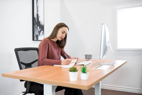 Girl sitting with a laptop at a standing desk 