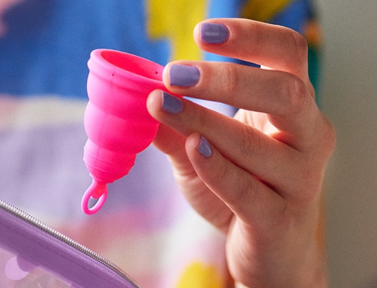 Hand holding Intimina Lily Cup One menstrual cup 