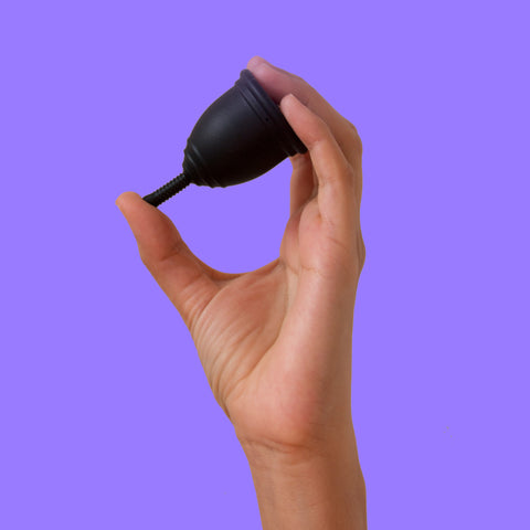 hand holding black menstrual cup