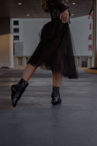 photo of a dancer wearing bsteps boots on pavement in parking garage