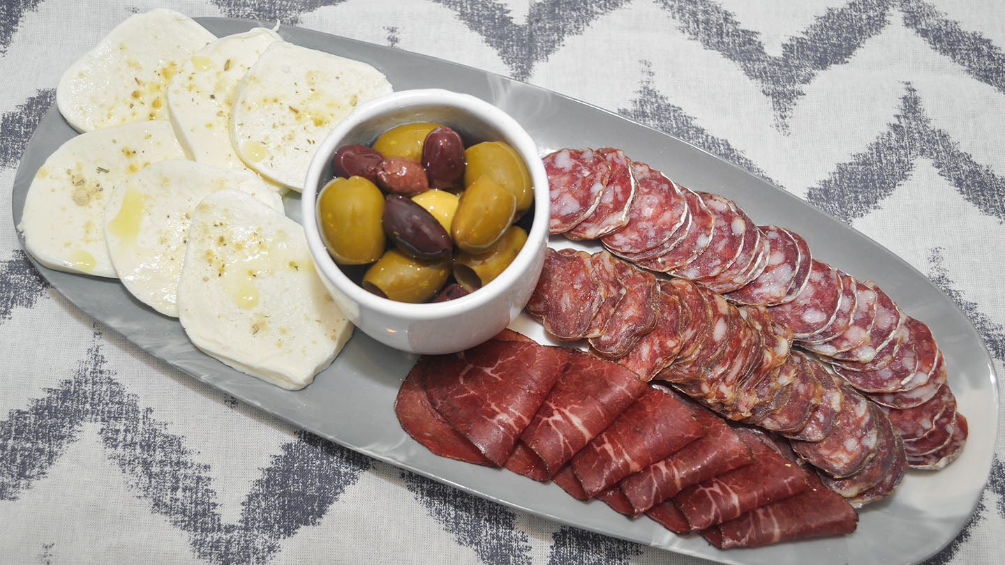 Antipasto of mozzarella, olives, and cured Italian sausages.