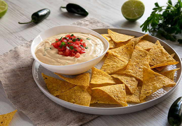 Queso dip served in a bowl with torilla chips.