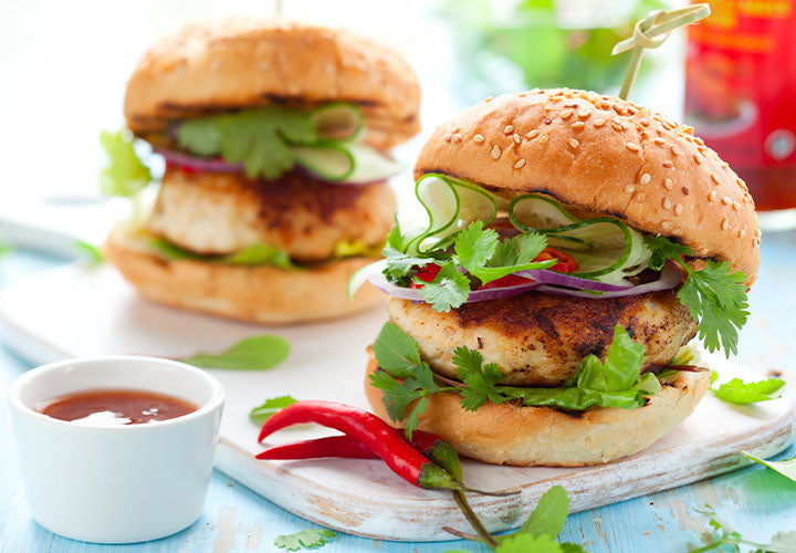 Spiced turkey burgers served on a sesame bun with lettuce, cilantro, onions, and cucumber.