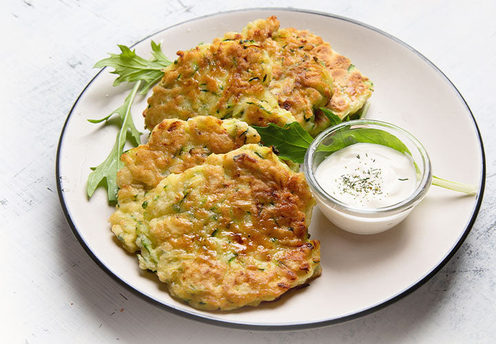 Zucchini pancakes served with onion sour cream dip.