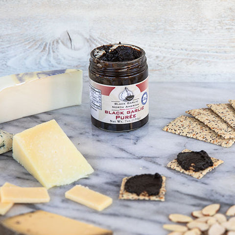 Black garlic puree with crackers, cheese, and nuts.
