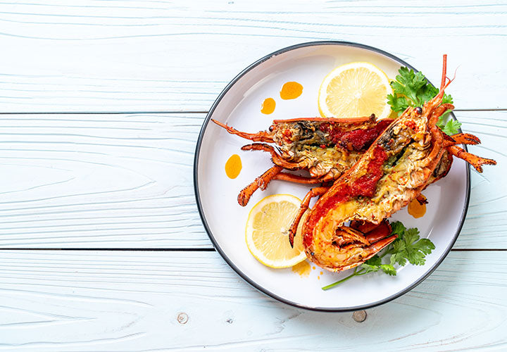 lobster on a plate with lemon, parsley, and garlic butter. Yummy!