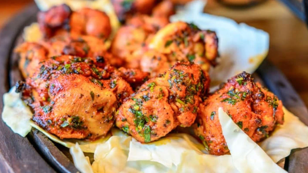 Spicy grilled Indian tandoori chicken served on a plate.