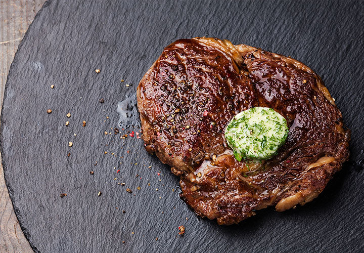 steak with garlic herb butter melting on top