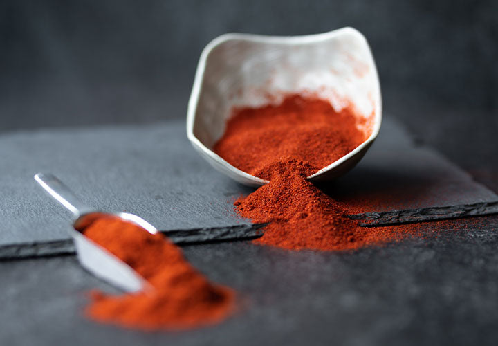 Fresh paprika spice in a bowl and spoon