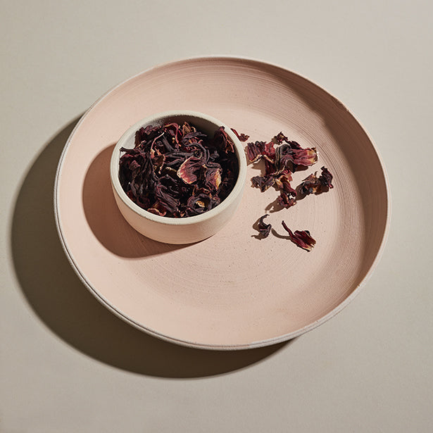 Hibiscus blossoms in a dish on a plate.