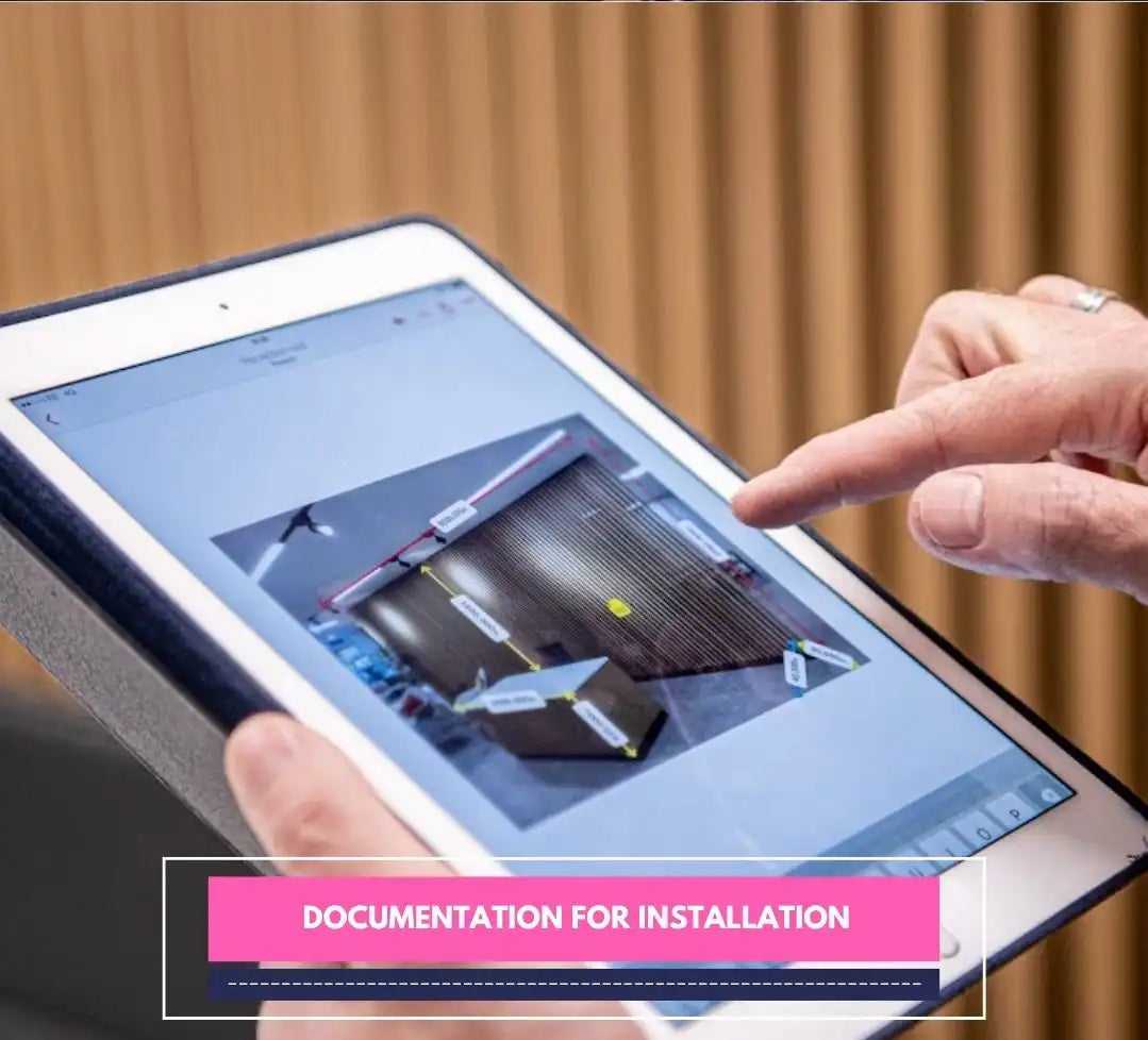 Finger pointing at tablet screen showing annotated wall for signage documentation